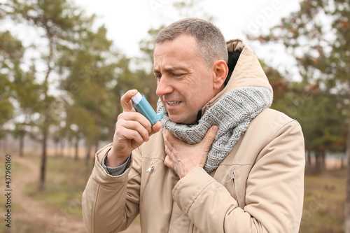 Senior man with inhaler hav...