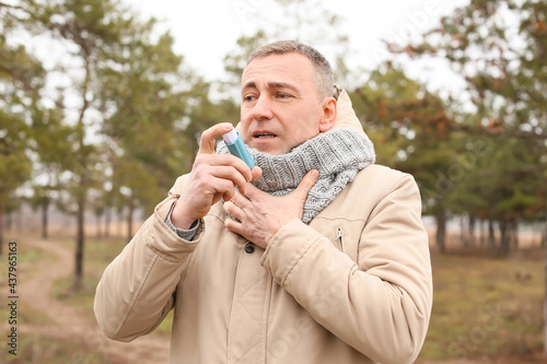 Senior man with inhaler hav...