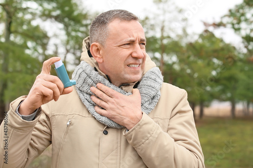 Senior man with inhaler hav...