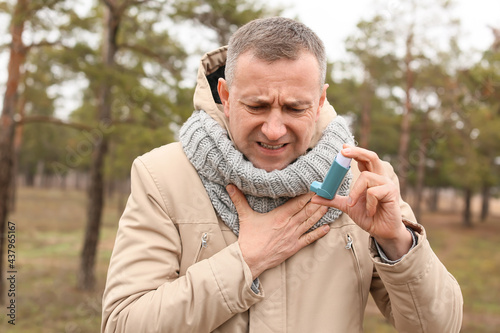 Senior man with inhaler hav...