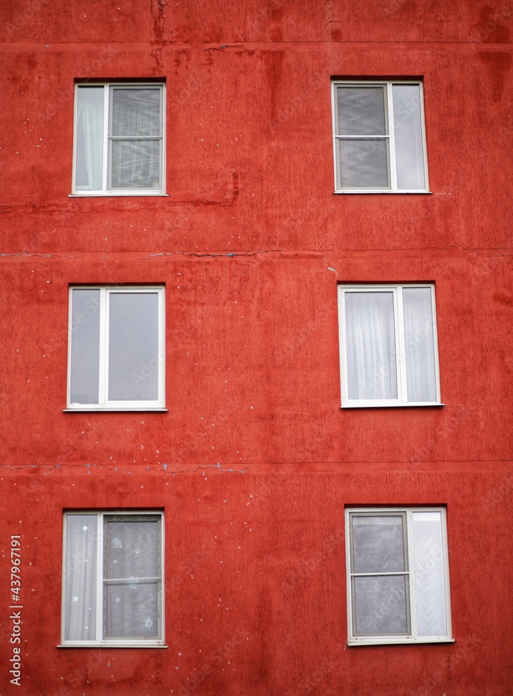 Red facade of a multi-storey building with plastic windows