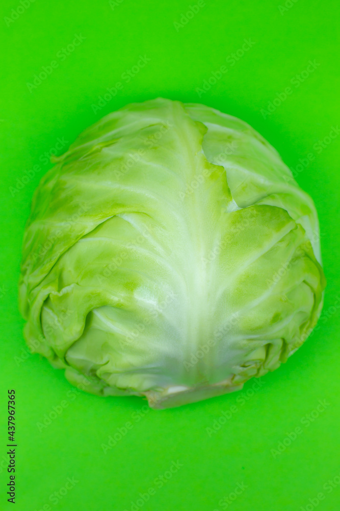 Obraz premium Green cabbage on the green background. Close up. Macro photo. Minimalism, original beautiful food photo.