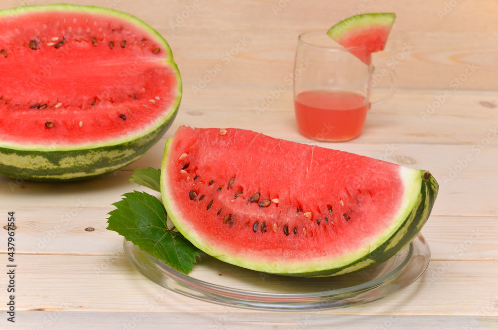 a large piece of watermelon and a glass of juice in the background