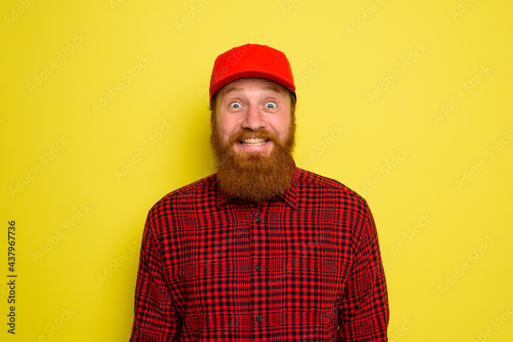 Delivery man with hat and beard has an happy expression Delivery man with hat and beard has an happy expression