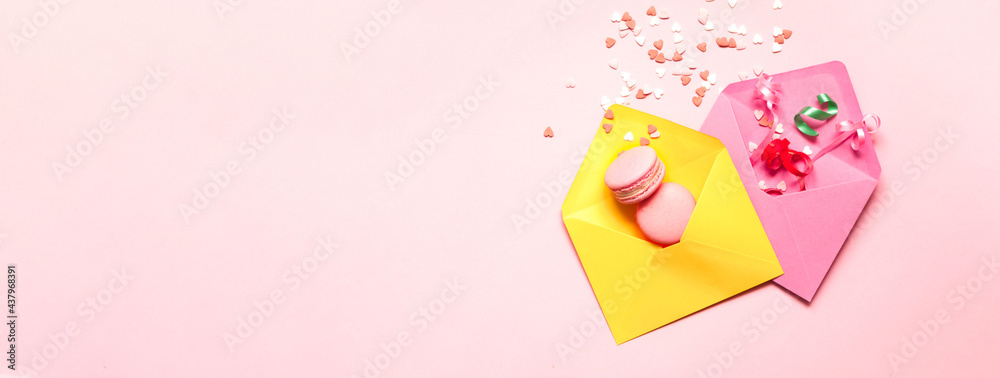 Colorful envelopes with pink macaroons and confetti. Festive concept or Romantic Love message. Creative copy space Colorful envelopes with pink macaroons and confetti. Festive concept or Romantic Love message. Creative copy space