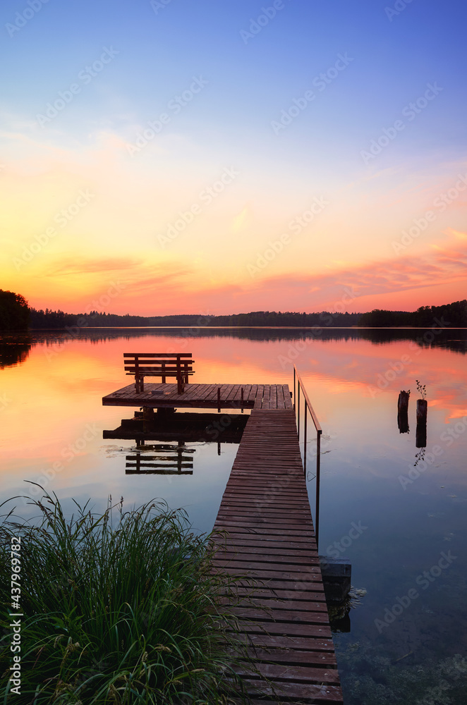 Bench on a wooden pier at sunset, Lipie Lake in Dlugie Village, Poland