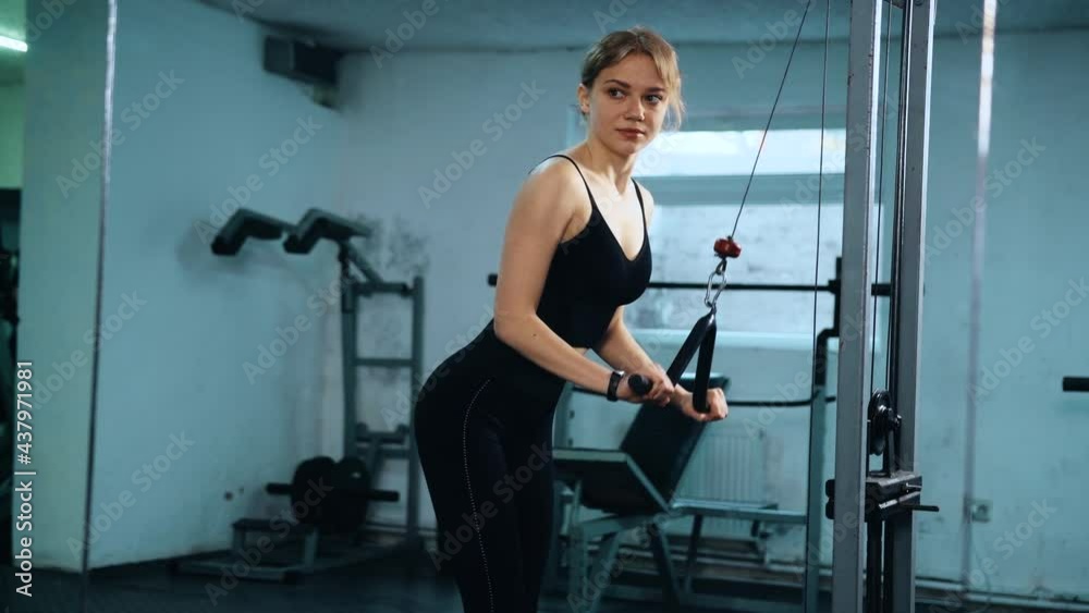 Athletic girl is engaged in a pectoral exercise machine in the gym. Woman keeps muscles toned and pulls dumbbells. The female is dressed in leggings and a top. 4k Athletic girl is engaged in a pectoral exercise machine in the gym. Woman keeps muscles toned and pulls dumbbells. The female is dressed in leggings and a top. 4k