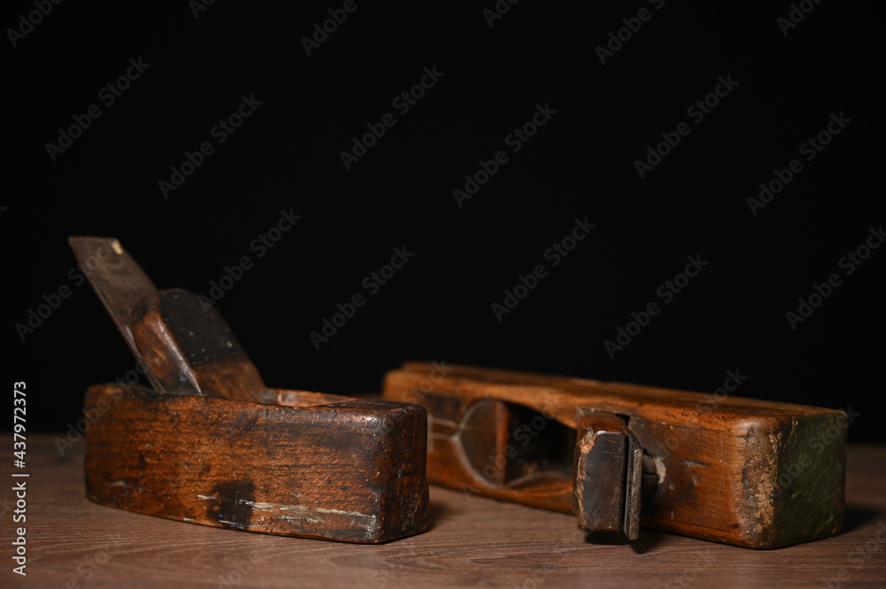 zwei alte dunkel braune antike holzhobel mit holzspan vor schwarzem hintergrund handwerk hobby zwei alte dunkel braune antike holzhobel mit holzspan vor schwarzem hintergrund handwerk hobby