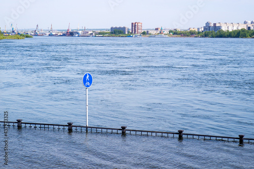 Cityscape of flooded embankment in Krasnoyarsk, Russia. Flooding of Yenisei River in spring during melting of snow and water discharge from the Krasnoyarsk Dam. Natural disaster