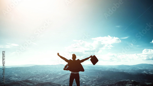 Silhouette of successful businessman keeping hands up hiking on the top of mountain - Celebrating success, winner and leader concept