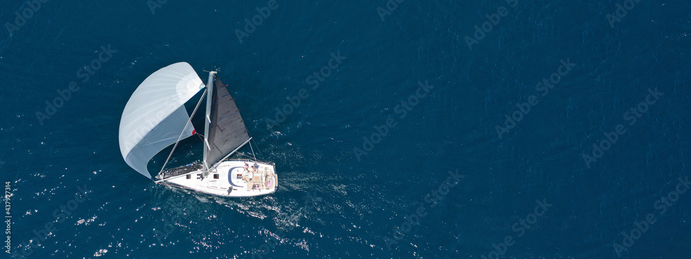 Aerial drone top down ultra wide photo of luxury sail boat cruising in the Aegean deep blue sea 