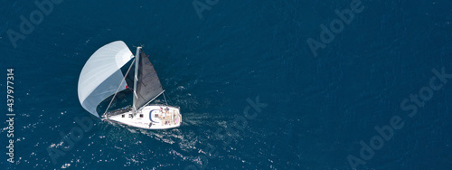 Aerial drone top down ultra wide photo of luxury sail boat cruising in the Aegean deep blue sea 