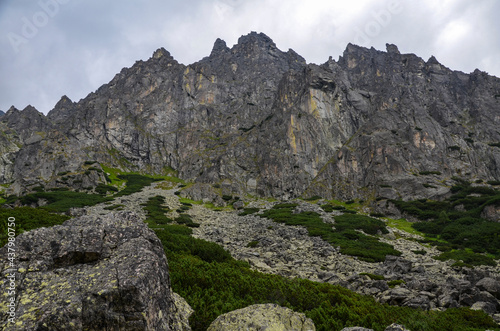 Landscape with high stone sharp rocky peaks under cloudy sky in National Park High Tatras Mountains, Slovakia. Tourist destination for hiking and tourism © Dmytro