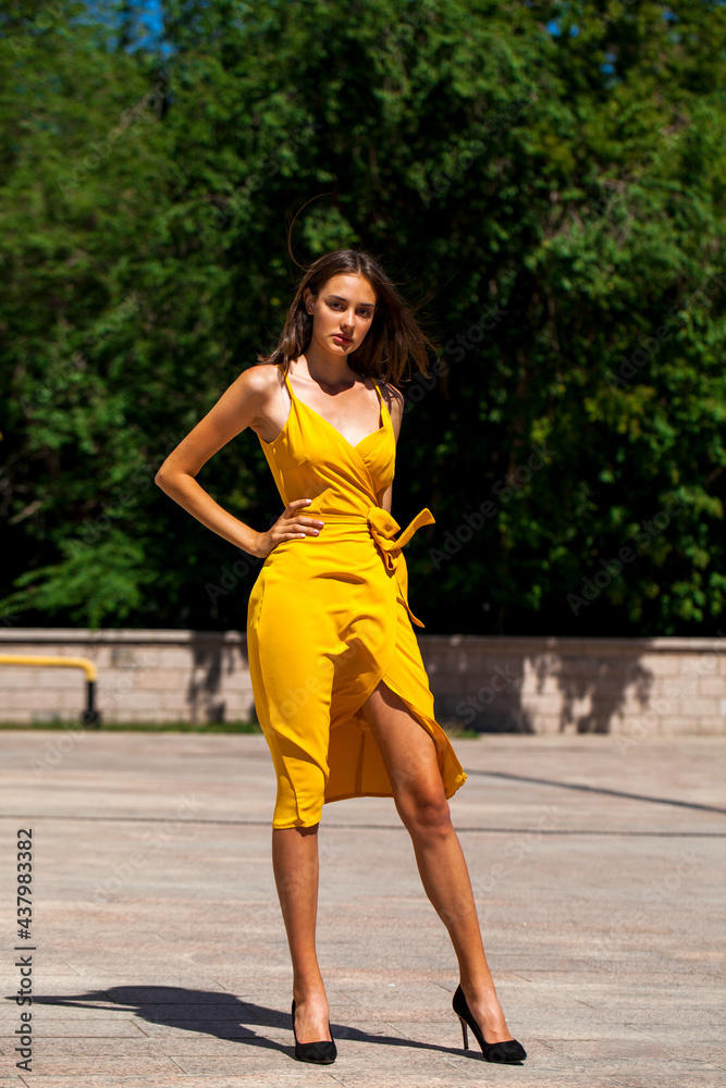 Young brunette woman in yellow dress