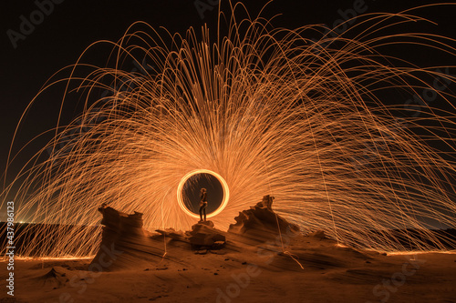 Steel wool photography at the desert rock structure at night time with fire splash all over. Slow Shutter speed photography with steel wool
