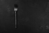 black fork on a black textured background