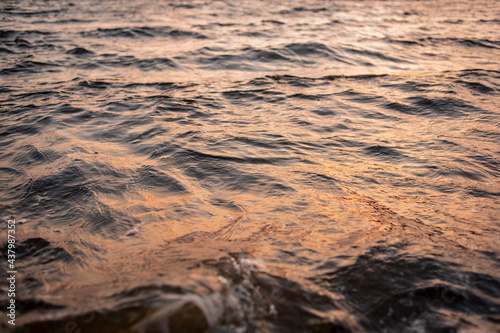 picture of the surface water in the sunset time. The texture of the river water at sunset.