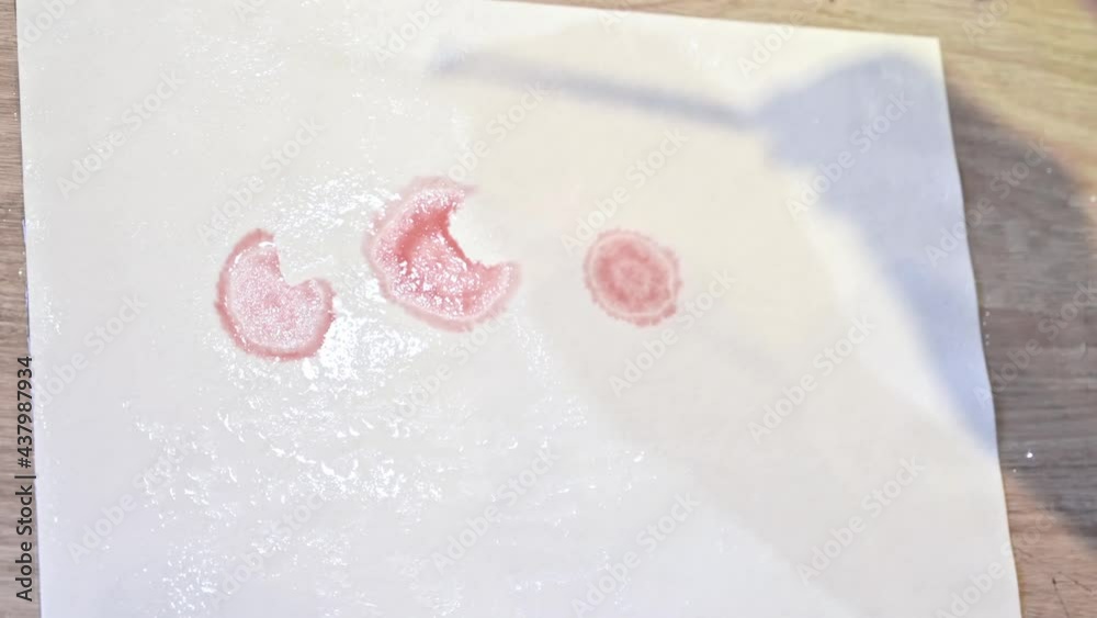 A woman in a studio painting on paper with red wine and brush, close view, slow motion A woman in a studio painting on paper with red wine and brush, close view, slow motion