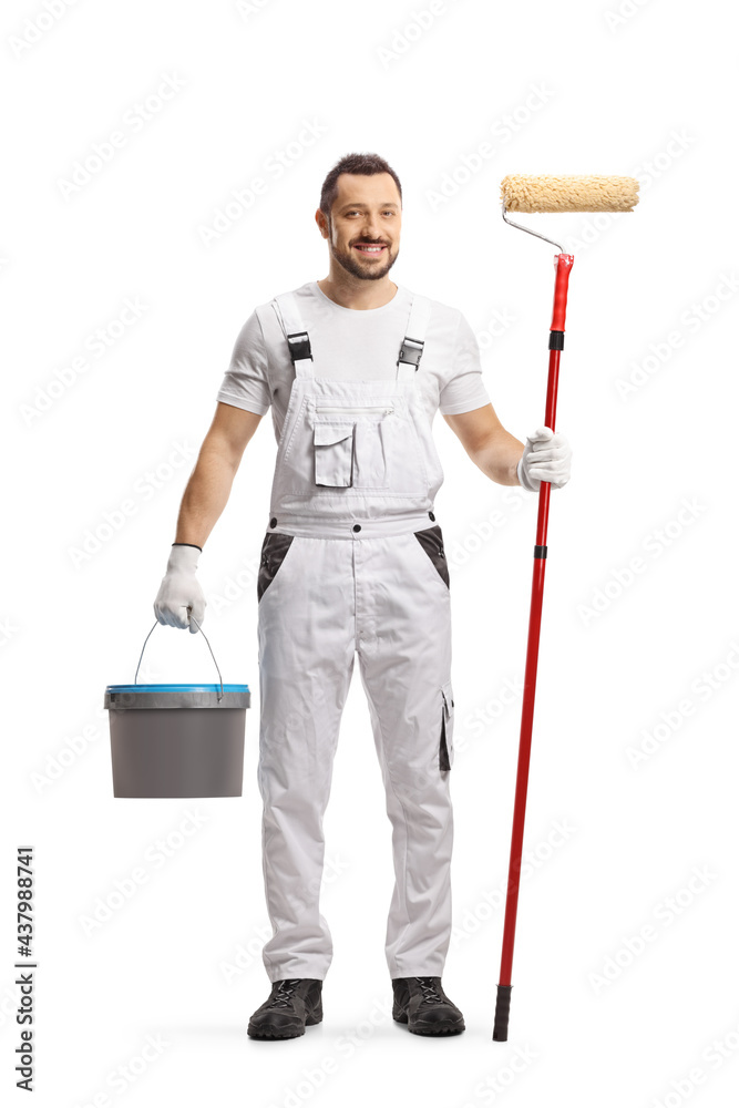 Full length portrait of a painter in a white uniform with a bucket and a paint roller Full length portrait of a painter in a white uniform with a bucket and a paint roller