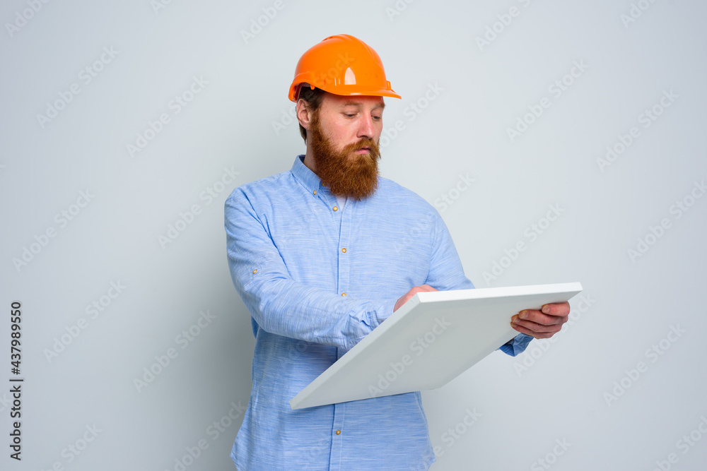 Confidant architect with beard and orange helmet does a sketch Confidant architect with beard and orange helmet does a sketch