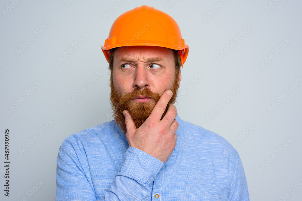Isolated doubter architect with beard and orange helmet