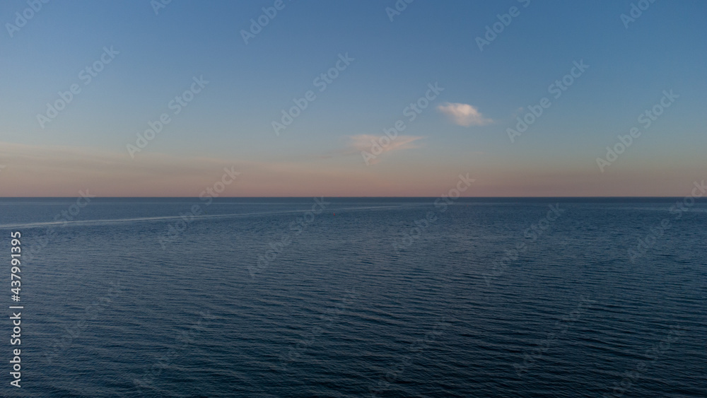 Calm sea at dawn. Blue sea and clouds.