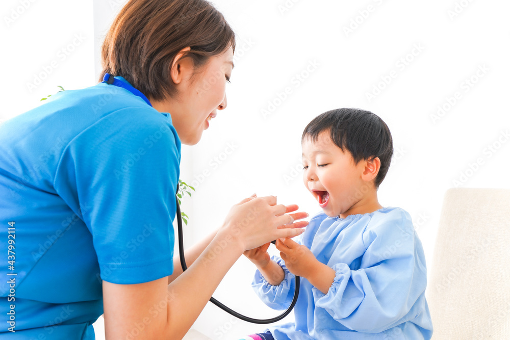 子どもを診察する若い看護師