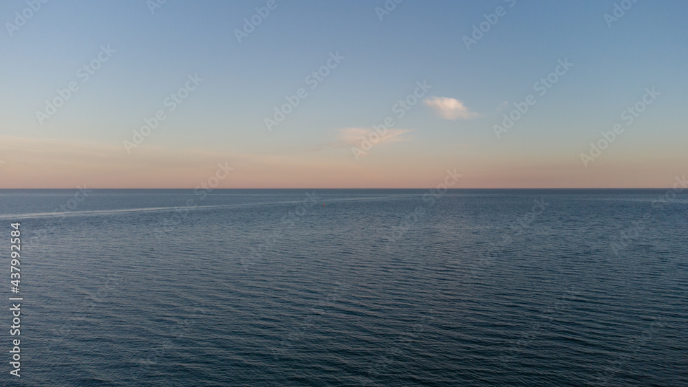 Calm sea at dawn. Blue sea and clouds.