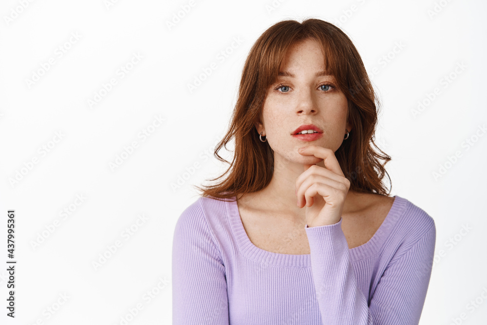 Close up portrait of attractive young woman with bangs, red lips and make up, looking thoughtful at camera, thinking or making decision, choosing, standing against white background Close up portrait of attractive young woman with bangs, red lips and make up, looking thoughtful at camera, thinking or making decision, choosing, standing against white background