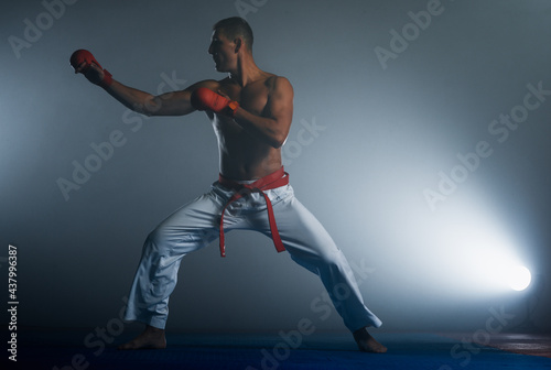 The karate guy in white kimono and red belt training karate