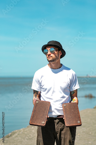 Sochi, Russia, 05.03.2021 a young stylish male yogi with tattoos stands on a sadhu board with nails