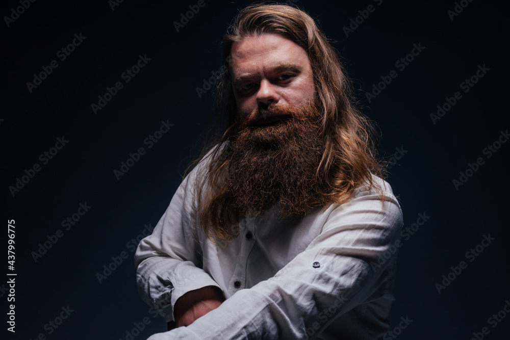 Fototapeta premium Close up portrait of handsome manly guy with beard posing in studio on a isolated background.