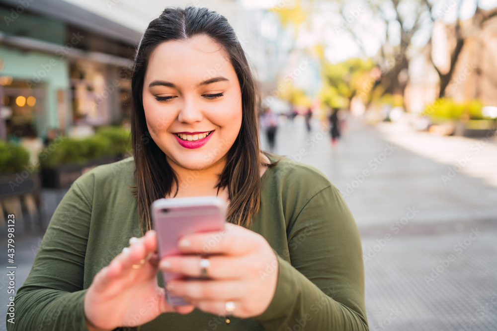 Young plus size woman using her mobile phone. Young plus size woman using her mobile phone.