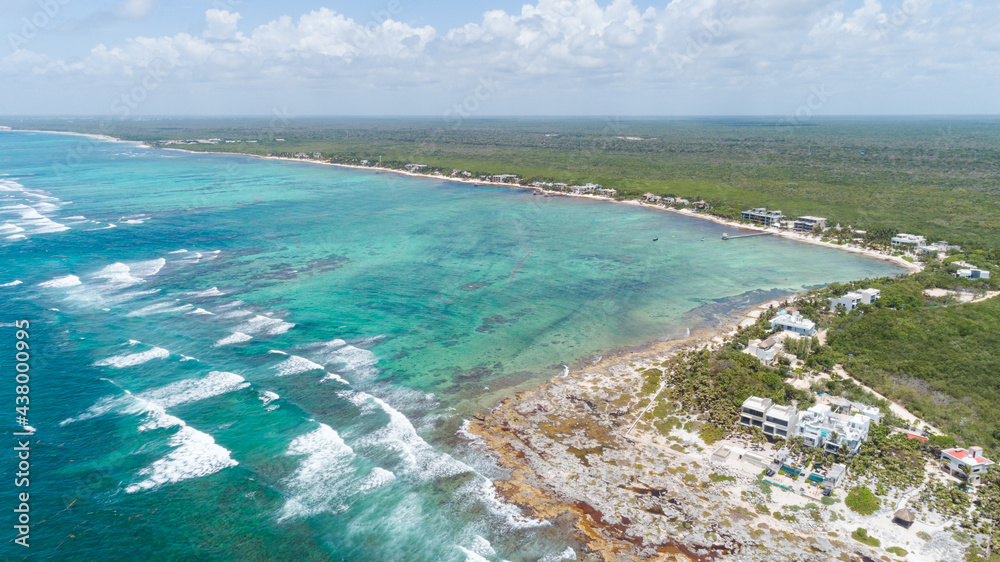 Drone shot over a peninsula in the Caribbean oceanfront of Tulum, Mexico.