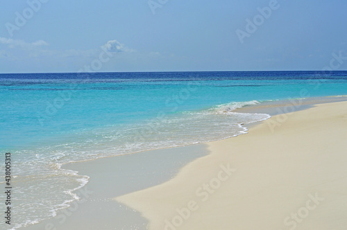 Sea waves run overwhelmingly on sand beach in Maldives