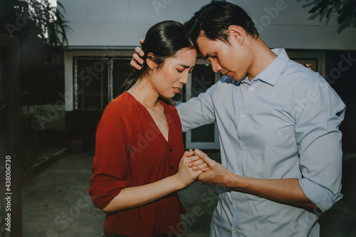 Принти на полотні Concept house sales and relocation : 
Couple stood together in front of the old house in sorrow and crying, wanting to sell the house and move away from the original home
