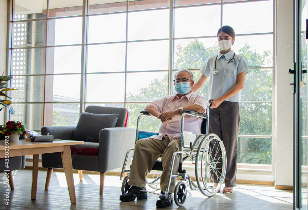 senior man at the nursing home concept. A female nurse stands holding a wheelchair with an elderly person sitting with the nursing home care. senior man at the nursing home concept. A female nurse stands holding a wheelchair with an elderly person sitting with the nursing home care.