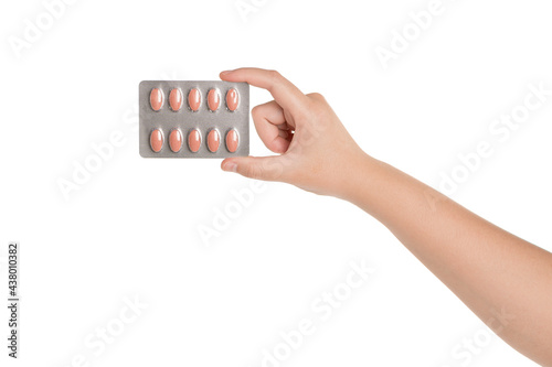 Woman hand holding pills blister pack isolated on white background.