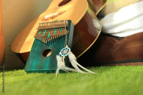 Kalimba or mbira is an African musical instrument.Traditional small Kalimba made from  wooden board with metal, play on  hands and plucking the tines with the thumbs. Instrument in room photo