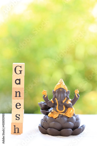 Ganesh or Ganesha statue on green bokeh background, is Ganapati in Hindu. He has elephant head with human body. Hindulism pray him in Diwali chaturthi. photo