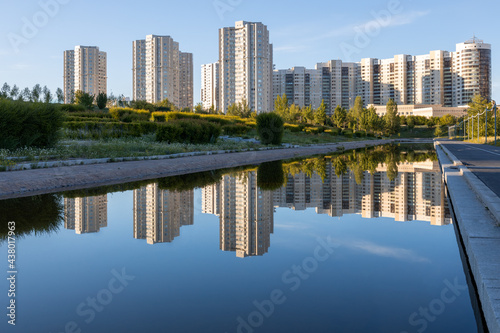 Apartment buildings and their reflection in the canal water in sunny summer day.