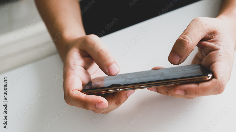 Man playing game on mobile phone. gamer boy playing video games holding Smartphone working mobile devices. cell telephone technology e-commerce concept Man playing game on mobile phone. gamer boy playing video games holding Smartphone working mobile devices. cell telephone technology e-commerce concept