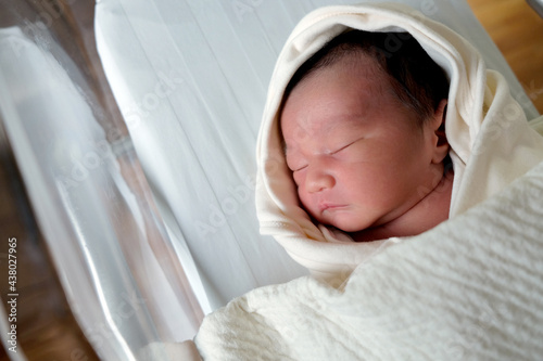 beautiful new born cute infant asleep in the blanket in delivery room