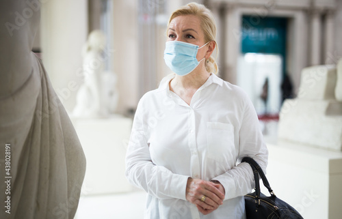 Portrait of senior woman in protective face mask, visiting historical museum