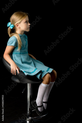 Side view of girl sitting on high chair