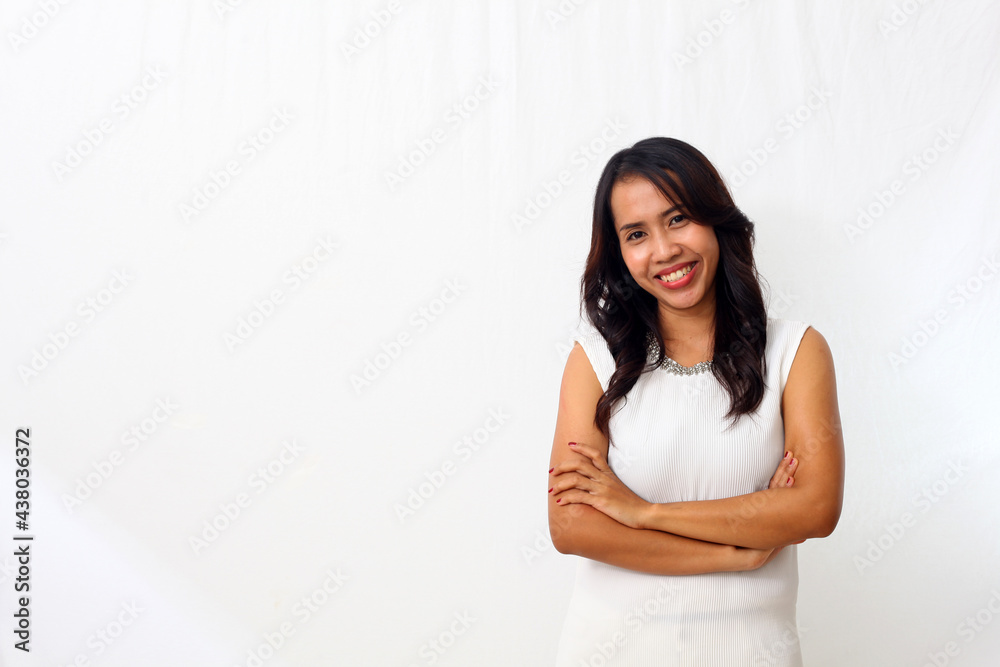 The beautiful young Asian girl smiled as she folded her arms and looked at camera. Isolated on white background The beautiful young Asian girl smiled as she folded her arms and looked at camera. Isolated on white background