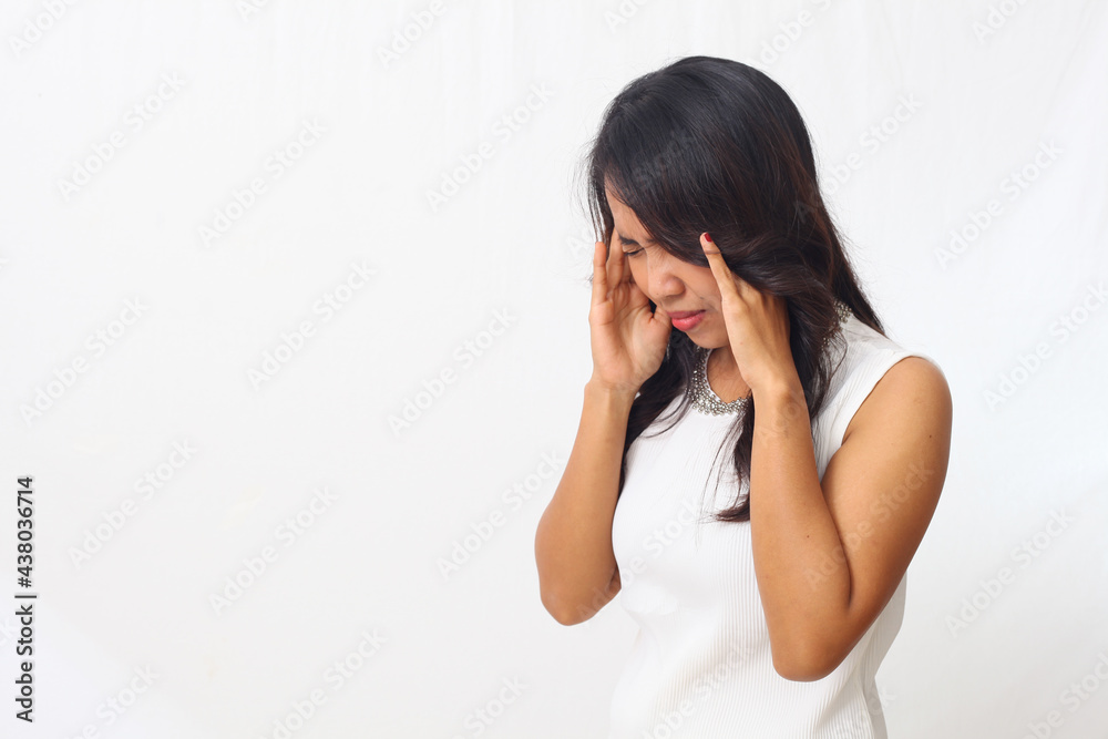 Beautiful asian girl standing while holding her head. headache concept. Isolated on white background with copyspace Beautiful asian girl standing while holding her head. headache concept. Isolated on white background with copyspace