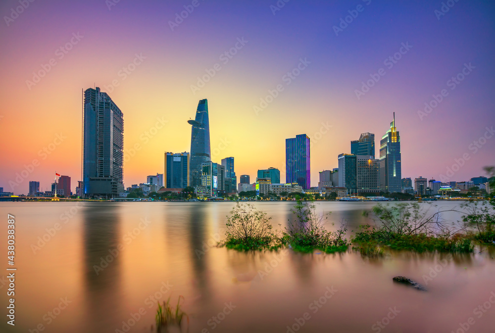 Riverside city sunset moments in the sky at end of day brighter coal sparkling skyscrapers along beautiful river in Ho Chi Minh City, Vietnam Riverside city sunset moments in the sky at end of day brighter coal sparkling skyscrapers along beautiful river in Ho Chi Minh City, Vietnam
