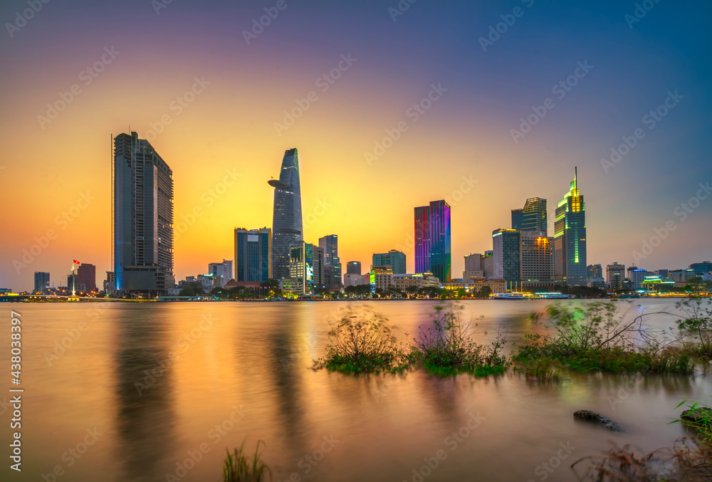 Riverside city sunset moments in the sky at end of day brighter coal sparkling skyscrapers along beautiful river in Ho Chi Minh City, Vietnam