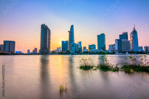 Riverside city sunset moments in the sky at end of day brighter coal sparkling skyscrapers along beautiful river in Ho Chi Minh City  Vietnam